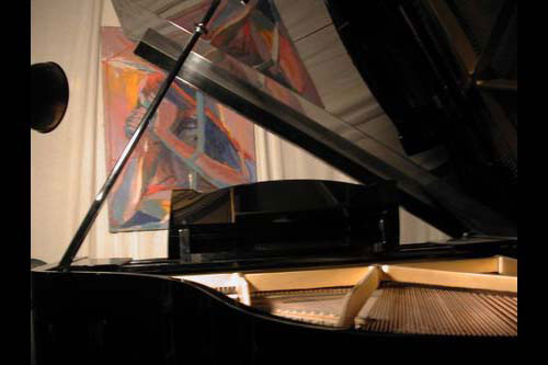 Artwork by Mary Bell behind the Yamaha Grand piano